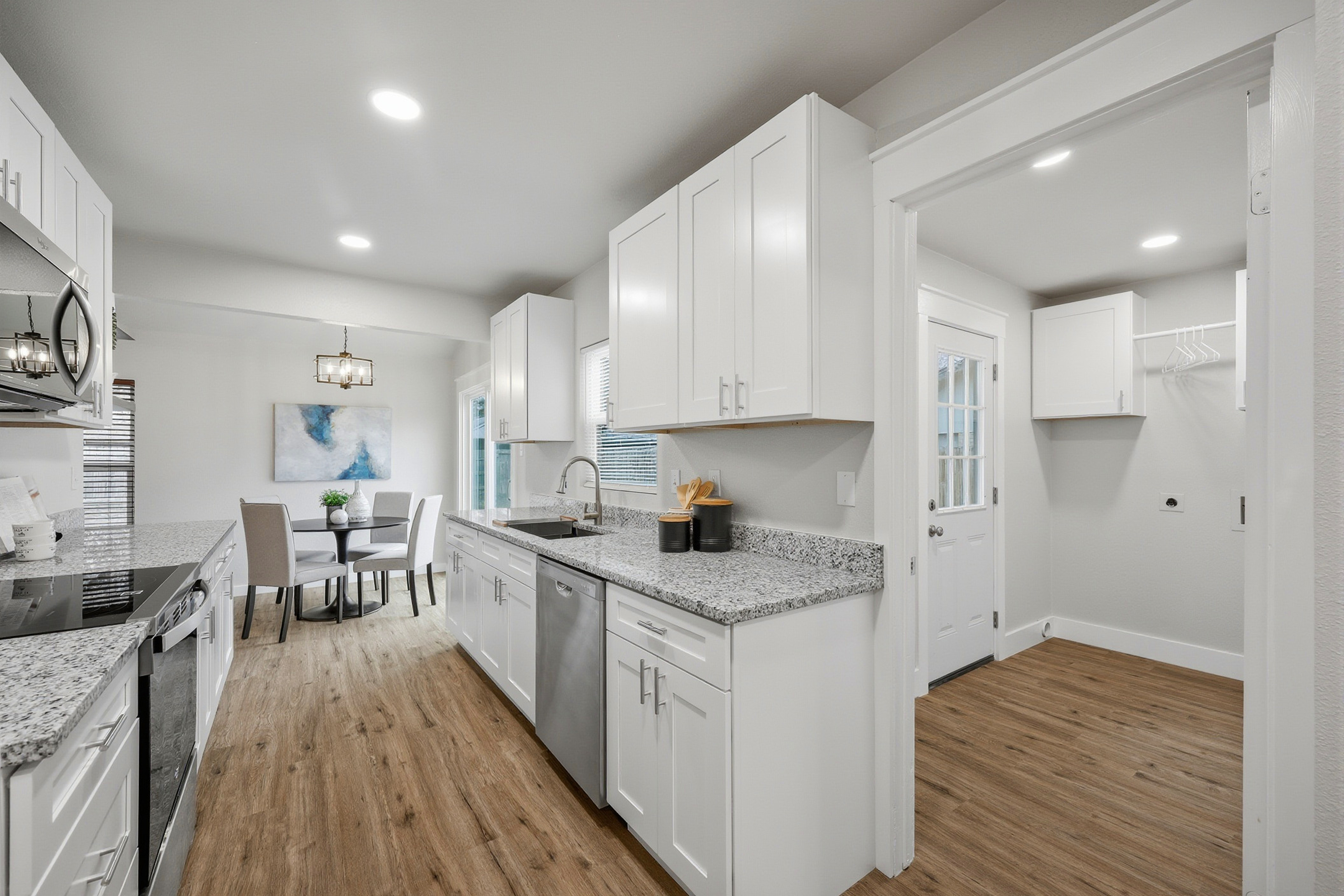 Kitchen with stainless dishwasher and open view through to breakfast nook